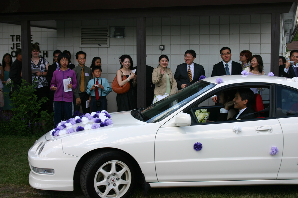 Украшение белой свадебной машины фиолетовыми цветами