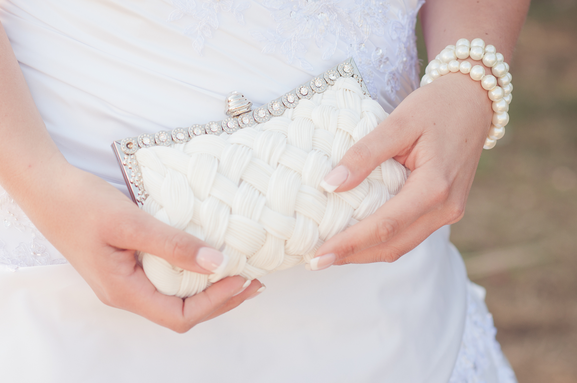 Белая свадебная сумочка в руках невесты